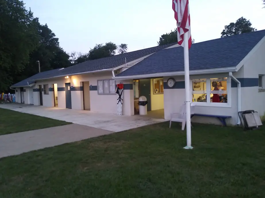The Wedgewood bathhouse and front desk building at dusk with the flagpole on the lawn