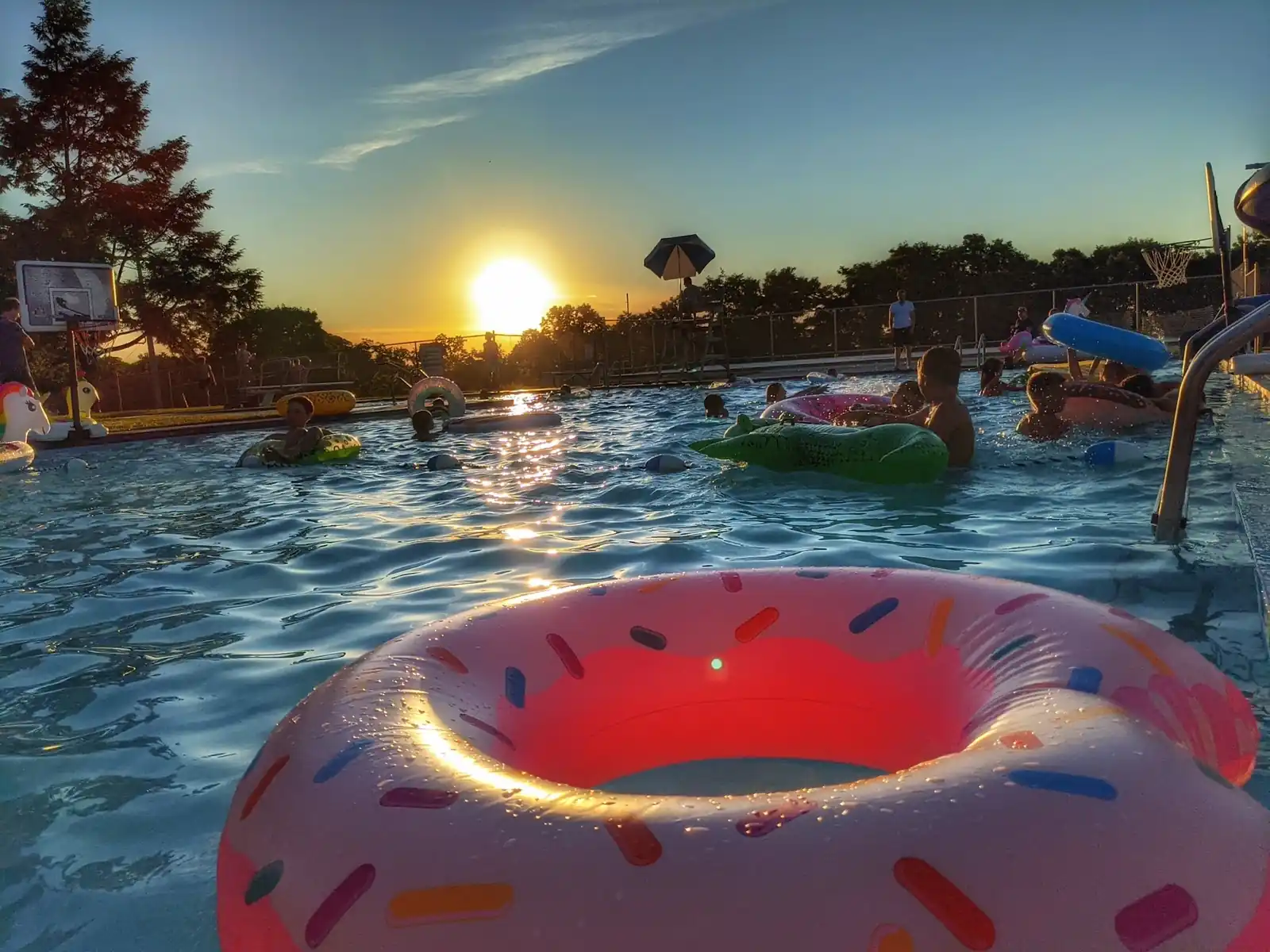 Sunset over the Main Pool with an inflatable ring floating near the ladder