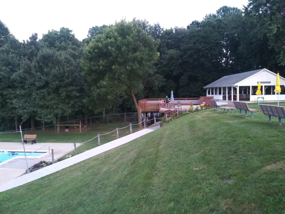 Grass slope down to the pools with the white pavilion and deck at the top